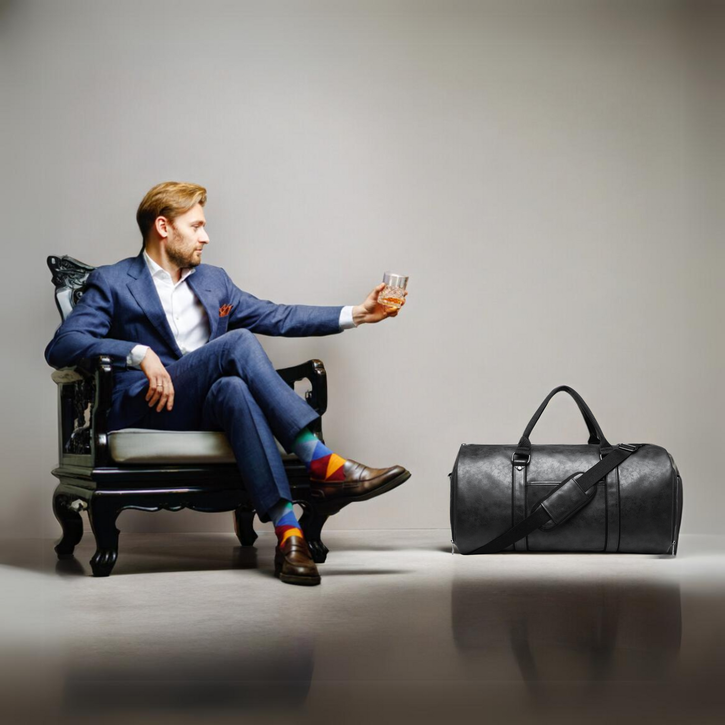 Borsa da viaggio in pelle nera abbinata a un look elegante da uomo